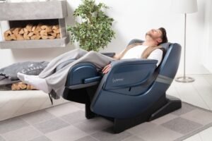 man stretched out in massage chair Casada ecosonic - blue in living room