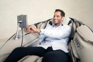 man in massagestoel Casada skyliner III - khaki die scherm gebruikt