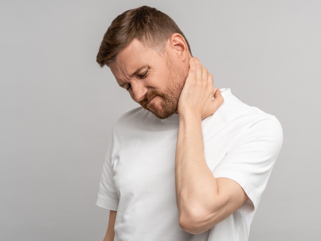 Mann im T-Shirt mit Symptomen eines beginnenden Leistenbruchs