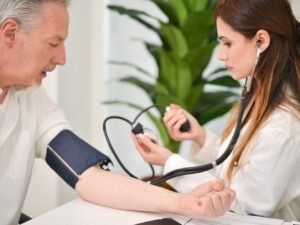 man bij dokter voor hoge bloeddruk stress