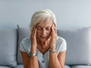 vrouw in zetel met hoofdpijn