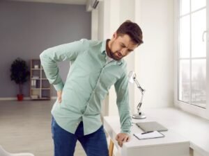 homme en chemise verte faisant des exercices de lumbago